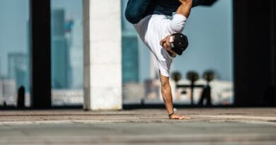 Ein Mann macht einen Handstand in einer Wasserpfütze.