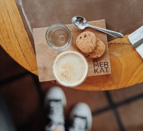 Eine Tasse Kaffee und Kekse auf einem Holztisch.